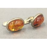 A boxed pair of silver amber cufflinks. Each 2 cm high.