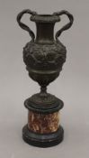 A 19th century cast patinated bronze urn on marble stand. 26 cm high.