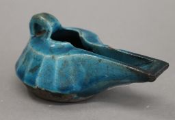 A Persian pottery oil lamp. 13 cm long.