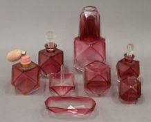 A quantity of cranberry glass dressing table items, etc.
