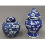 Two 19th century Chinese blue and white 'prunus blossom' vases and covers. The tallest 28 cm high.