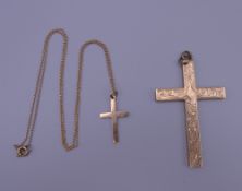 Two 9 ct gold crosses, one on a chain. The largest 5 cm high. 5.6 grammes.