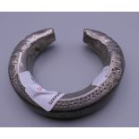 An Afghan white metal child's bracelet. 8 cm diameter.