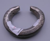 An Afghan white metal child's bracelet. 8 cm diameter.