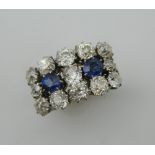 An 18 ct gold and platinum, diamond and sapphire three row cluster ring. 1.3 cm high.
