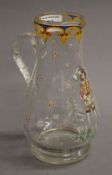 An enamel decorated clear glass ewer. 22 cm high.
