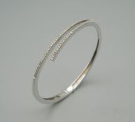 A 14 ct white gold and diamond bracelet. 6.5 cm wide. 13.8 grammes total weight.