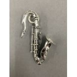 A pendant formed as a saxophone. 4.5 cm high.