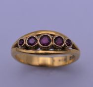 A 22 ct gold ruby five stone ring. Ring size M. 4.7 grammes total weight.