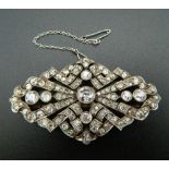 An unmarked white gold or platinum diamond set brooch of pierced navette form,