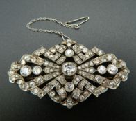 An unmarked white gold or platinum diamond set brooch of pierced navette form,