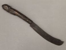 A tribal knife with figural carved wooden handle. 33 cm long.