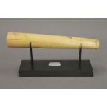 A late 19th century ivory pipe, on later stand. 18.5 cm long.