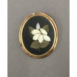 An unmarked gold mounted pietra dura brooch. 4 cm wide.