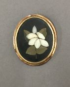 An unmarked gold mounted pietra dura brooch. 4 cm wide.