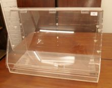 A perspex display case. 60.5 cm wide, 40.5 cm high, 30 cm deep.