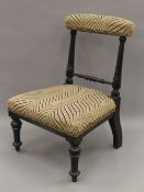 A Victorian upholstered ebonised child's chair. 50 cm high.