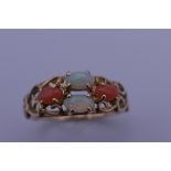A 14 ct gold opal and coral ring. Ring size P. 2.5 grammes total weight.