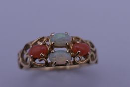 A 14 ct gold opal and coral ring. Ring size P. 2.5 grammes total weight.