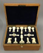 A late 19th/early 20th century oak cased ivory Staunton pattern chess set. The kings 8.5 cm high.