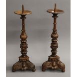 A pair of carved wooden pricket sticks. 56 cm high.