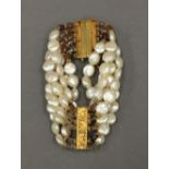 A pearl and gilt metal bracelet. 18 cm long.