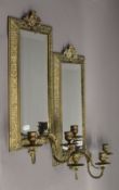 A pair of brass mirrored girandoles. 52 cm high, 23 cm wide.