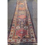 A large red ground runner. 100 x 484 cm.