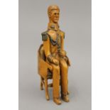 A late 19th/early 20th century treen model of a military officer seated in a plush covered chair.