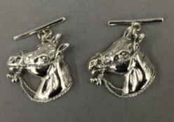 A pair of silver horse cufflinks. 2 cm high.