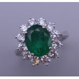 An 18 ct white gold emerald and diamond ring.