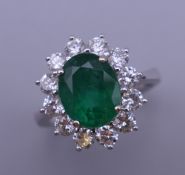 An 18 ct white gold emerald and diamond ring.