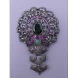 A vintage pendant set in silver and gold with rubies, diamonds and emeralds. 7 cm high.