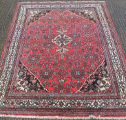 A large red ground wool rug. 210 x 290 cm.