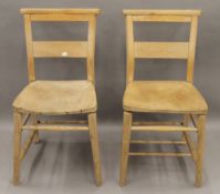 A pair of elm seated chapel chairs.