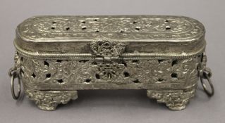 An Afghan white metal box with hinged lid with clasp, tooled open work. 16 cm long.