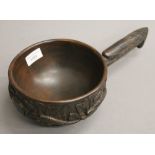 A carved wooden bowl with an eagle form handle. 18 cm diameter.