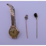 Two stick pins and a ladies gold cased wristwatch.
