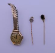 Two stick pins and a ladies gold cased wristwatch.