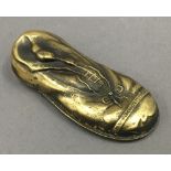 A brass vesta formed as a boot. 7 cm long.