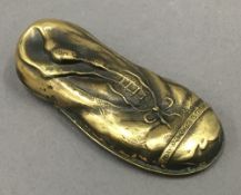 A brass vesta formed as a boot. 7 cm long.