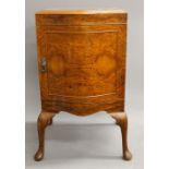 An early 20th century walnut bedside cupboard designed by Maurice Adams and manufactured by Maurice