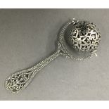 A silver ball rattle. 7.5 cm long.
