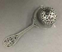 A silver ball rattle. 7.5 cm long.