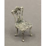 A miniature silver model of a chair. 5 cm high.