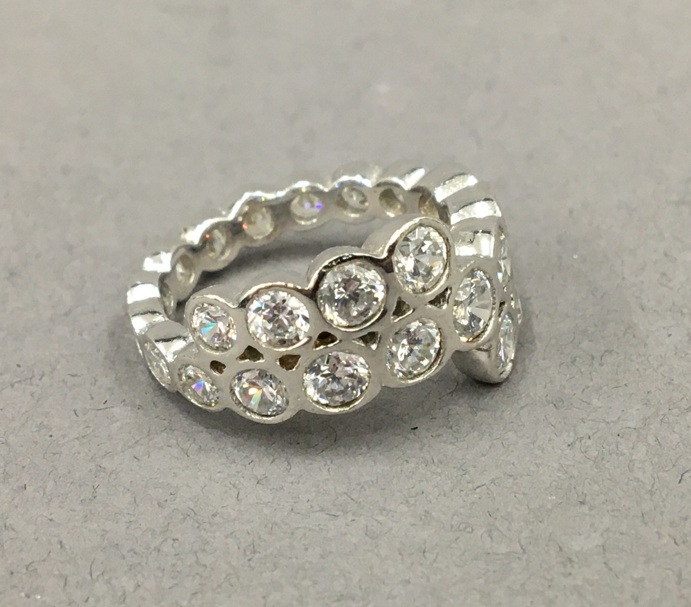 A silver cubic zirconia band ring.