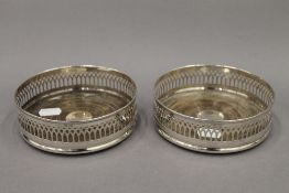 A pair of silver mounted bottle coasters. 13.5 cm diameter. 10.1 troy ounces total weight.