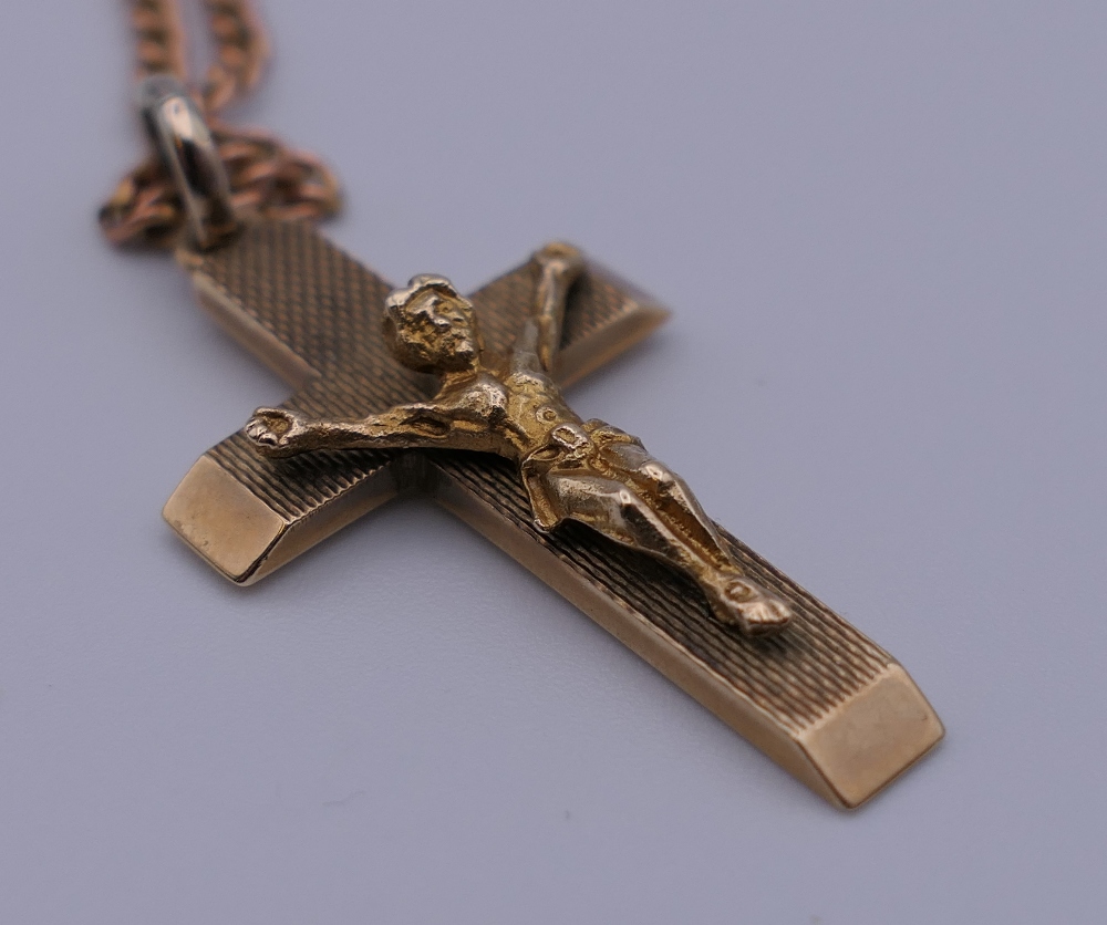 A 9 ct gold crucifix on a 9 ct gold chain. 3 cm high. 10.6 grammes. - Image 4 of 4