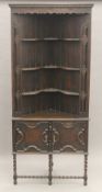 An early 20th century oak barley twist standing corner cabinet. 191.5 cm high.