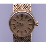 A 9 ct gold Omega ladies wristwatch. 1.5 cm wide. 23.7 grammes total weight.